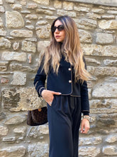 A lady wears a wool tweed jacket.